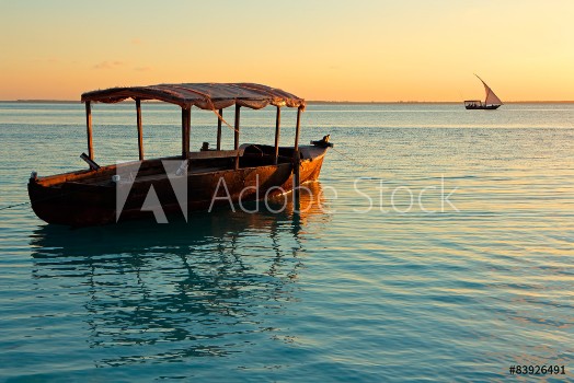 Picture of Wooden boat on water at sunset Zanzibar island